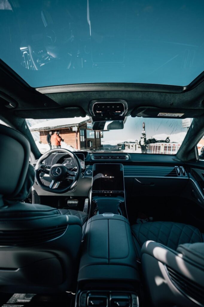 Intérieur d’une voiture avec sièges en cuir et toit panoramique vitré.