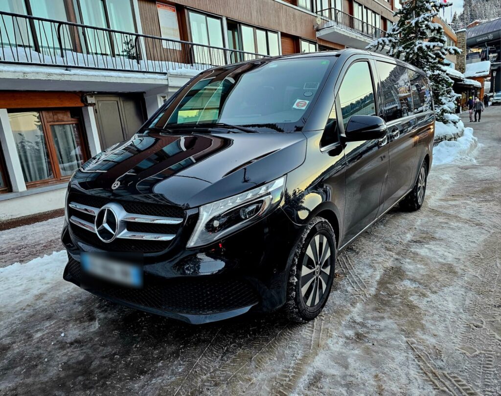 Van Mercedes noir stationné dans une rue enneigée.